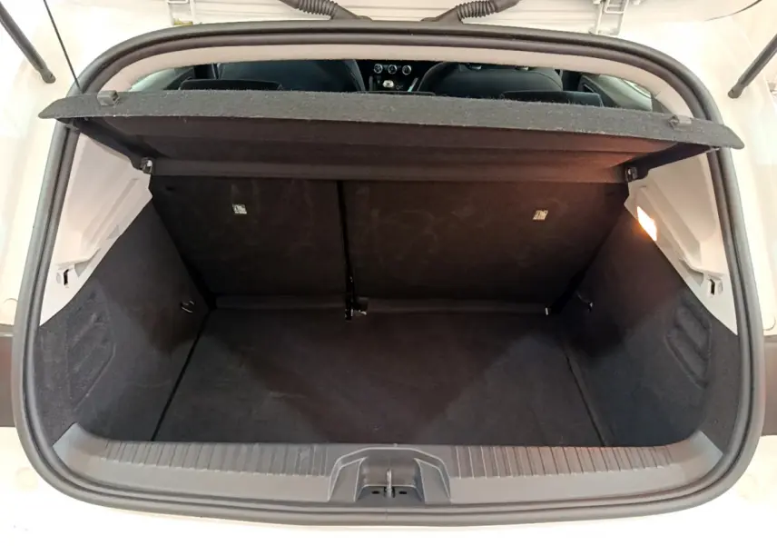 Vue du coffre ouvert d'une Renault Clio Business TCe 100 blanc, montrant l'espace de chargement et la tablette arrière.