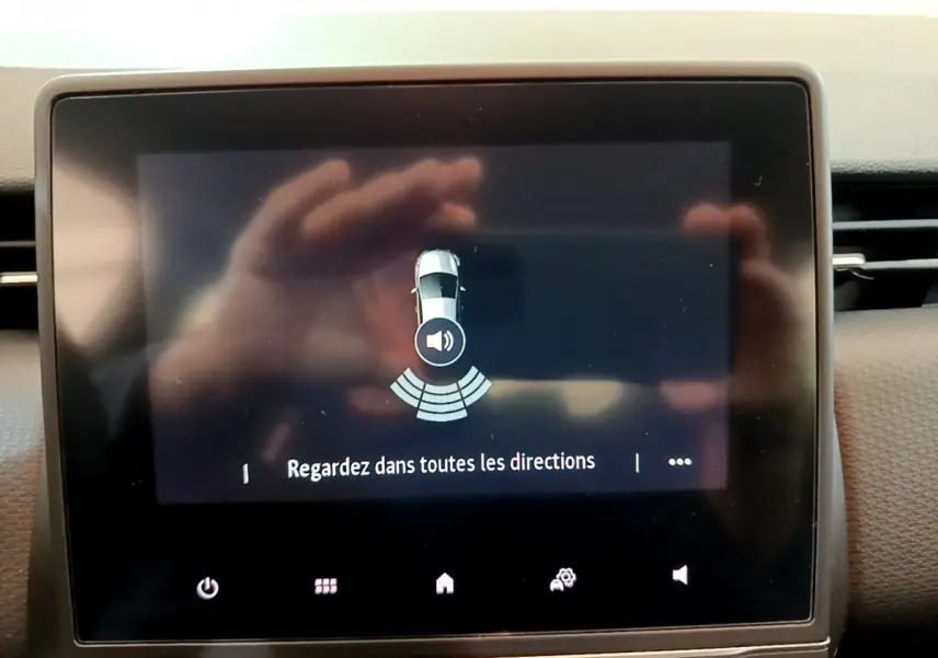 Écran tactile central de la Renault Clio Business blanc 2020 montrant l'alerte de détection d'obstacles.