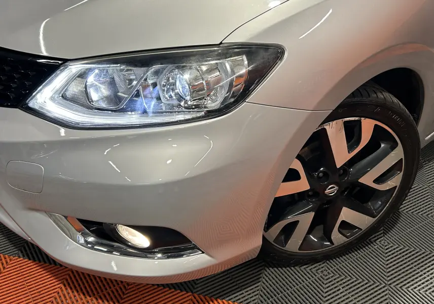 Gros plan sur l'avant droit gris d'une Nissan Pulsar 2018, mettant en valeur le phare LED et la jante alliage noire et argent.