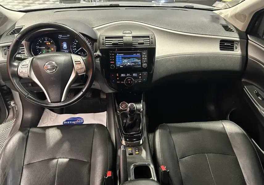 Vue intérieure frontale du tableau de bord et des sièges noirs en cuir d'une Nissan Pulsar 1.5 dCi 110ch Ultimate de 2018.