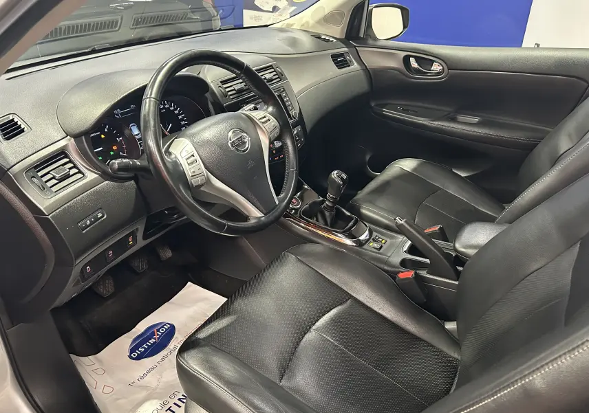 Vue intérieure côté conducteur du Nissan Pulsar 1.5 dCi 2018 avec sièges cuir noirs et boîte manuelle visible.
