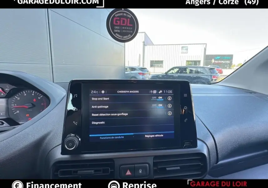 Vue intérieure centrée sur l'écran tactile du tableau de bord du Peugeot Rifter bleu 2024, affichant les réglages du véhicule.