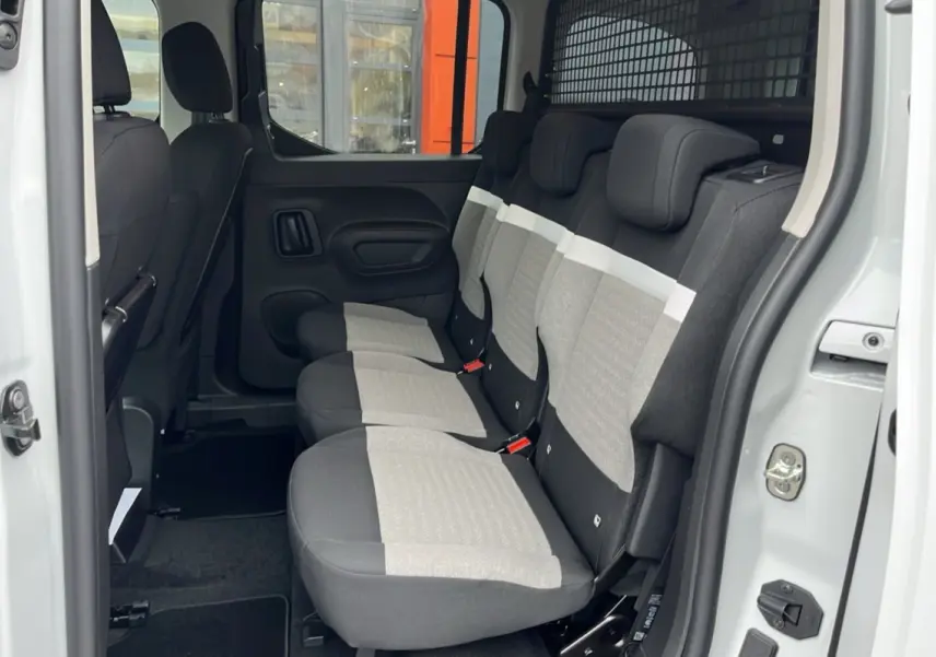 Vue latérale des sièges arrière tissu gris clair et noir du Citroën Berlingo Kaolin White avec grille de séparation amovible.