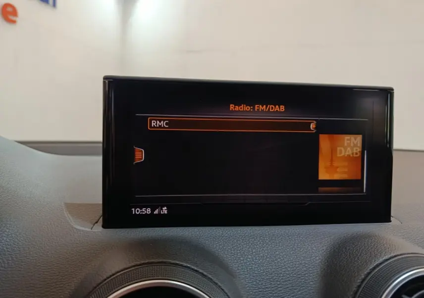 Écran tactile central affichant la radio FM/DAB dans l'habitacle gris foncé de l'Audi Q2 35 TFSI Business Line.