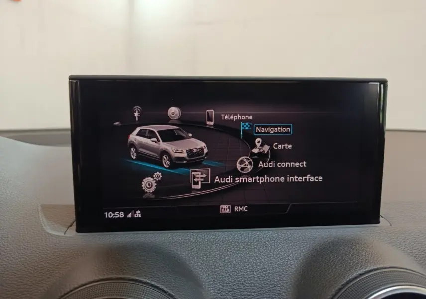 Écran tactile intérieur affichant le menu de navigation avec une image grise de l'Audi Q2 en vue 3/4 avant.