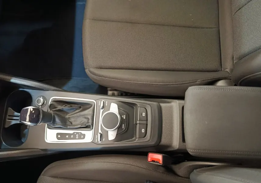 Vue plongeante sur la console centrale noire de l'Audi Q2 35 TFSI 150 S Tronic Business Line avec levier de vitesse automatique.