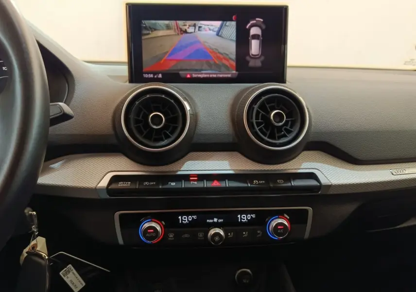 Vue intérieure du tableau de bord de l'Audi Q2 gris foncé, avec écran tactile affichant la caméra de recul.