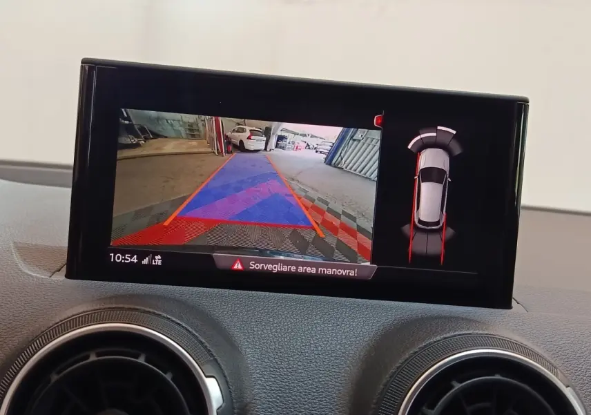 Écran tactile intérieur montrant la caméra de recul et l'aide au stationnement de l'Audi Q2 35 TFSI gris foncé.