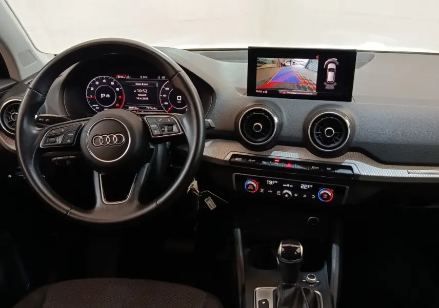 Vue intérieure de l'Audi Q2 35 TFSI 2022, tableau de bord avec écran tactile et volant cuir multifonctions noir.