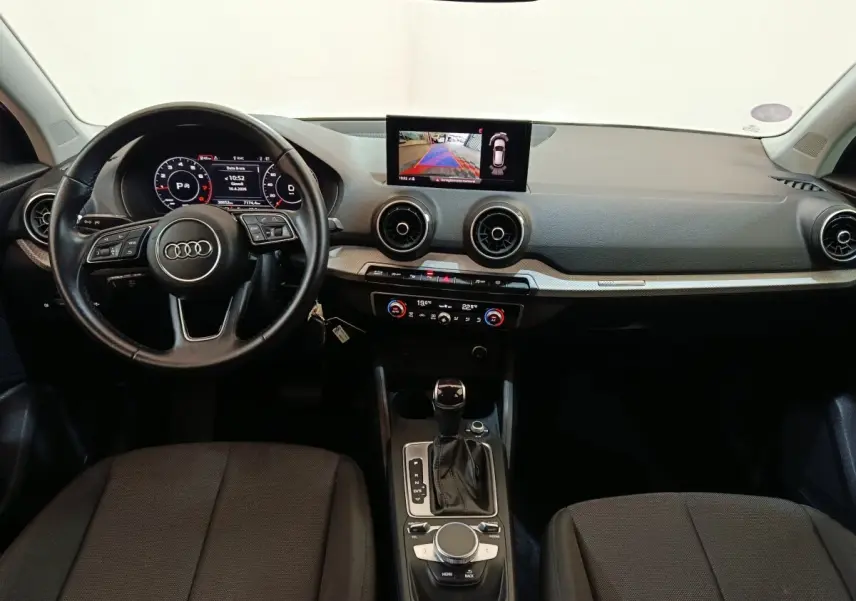 Vue intérieure frontale de l'Audi Q2 35 TFSI 150 S Tronic Business Line 2022, tableau de bord noir avec écran tactile central.