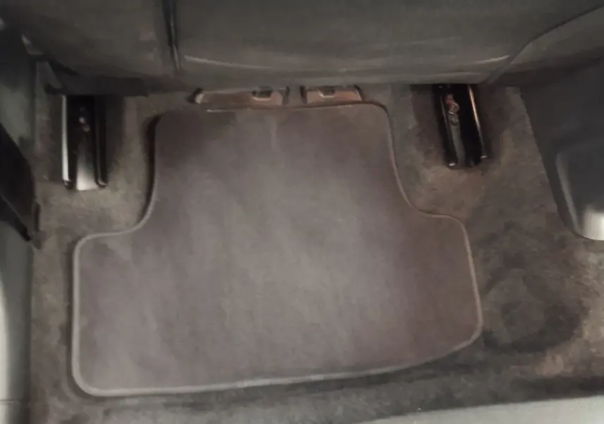 Plancher côté passager avec tapis de sol gris foncé dans un Audi Q2 35 TFSI 2022, vue rapprochée intérieure.