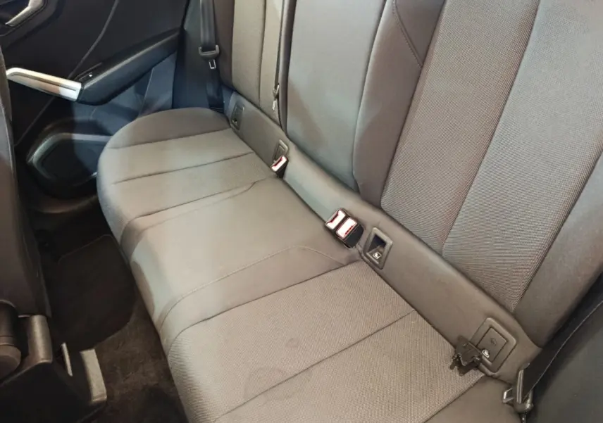 Vue intérieure côté droit de la banquette arrière grise foncée de l'Audi Q2 35 TFSI 2022 avec ceintures et fixations Isofix visibles.