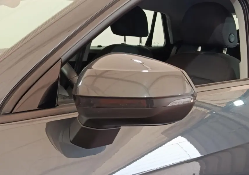 Rétroviseur droit gris foncé d’un Audi Q2 35 TFSI 150 S Tronic Business Line, intérieur noir visible.