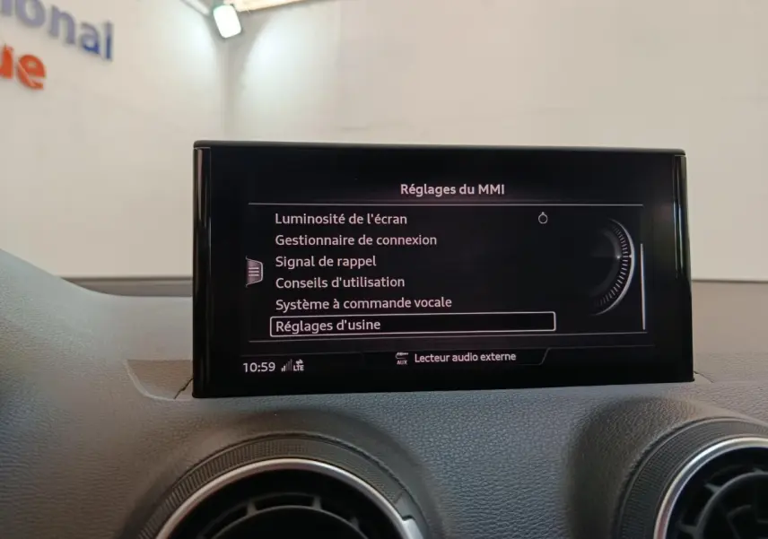 Écran central tactile affichant les réglages du MMI sur le tableau de bord gris d’un Audi Q2 35 TFSI 2022.