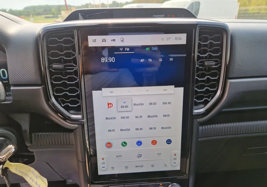 Vue rapprochée de l’écran tactile central 12,4 pouces du Ford Ranger Super Cabine blanc, avec commandes climatisation et audio visibles.