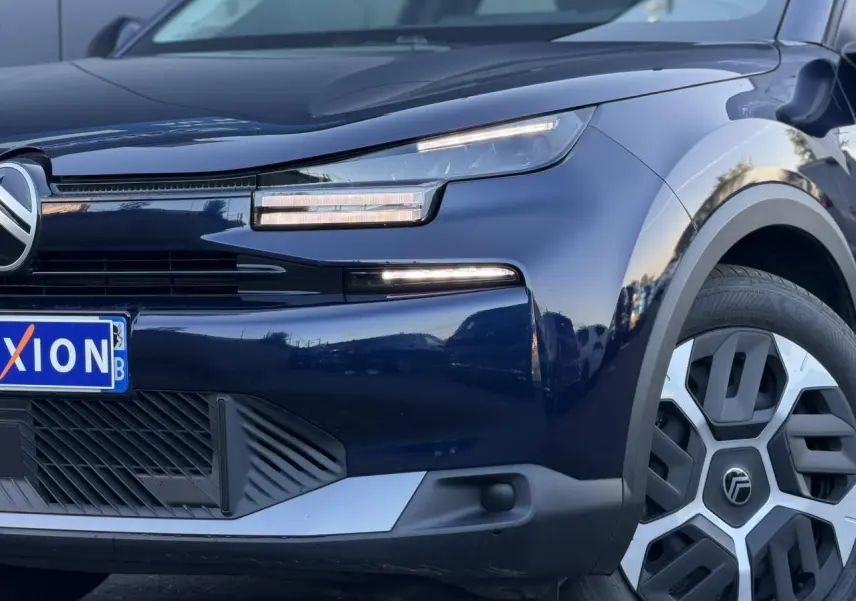 Vue 3/4 avant droit d'une Citroën C4 Hybrid 145 bleu Eclipse avec phares LED et jante au design moderne.