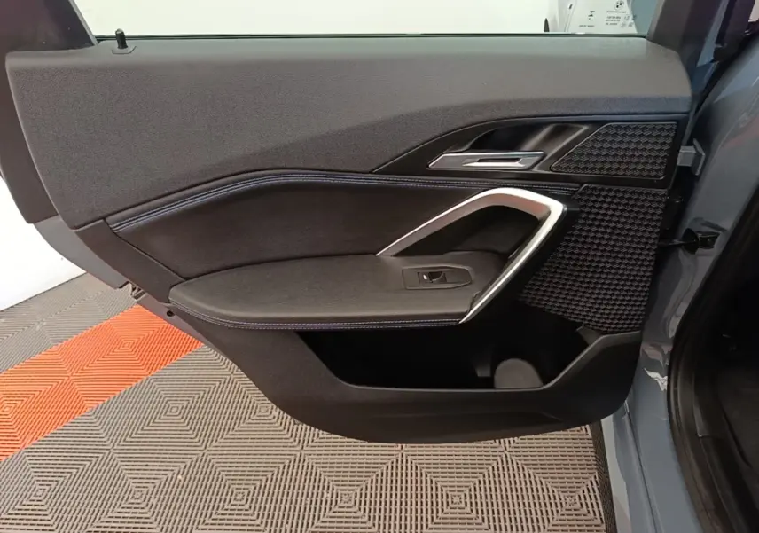 Vue rapprochée de la porte avant droite gris foncé du BMW X1 xDrive25e M Sport avec garniture noire et insert alu.