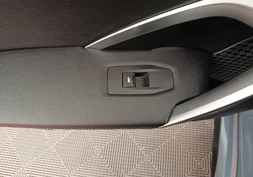 Détail de la poignée intérieure côté conducteur du BMW X1 xDrive25e M Sport gris foncé avec bouton de verrouillage.