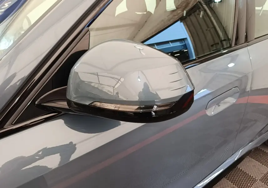 Rétroviseur côté conducteur gris foncé avec clignotant intégré sur BMW X1 xDrive25e M Sport 2023, vue latérale rapprochée.