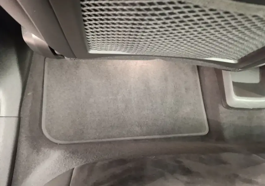 Vue intérieure du plancher avant droit du BMW X1 xDrive25e M Sport gris foncé, avec tapis de sol gris clair.