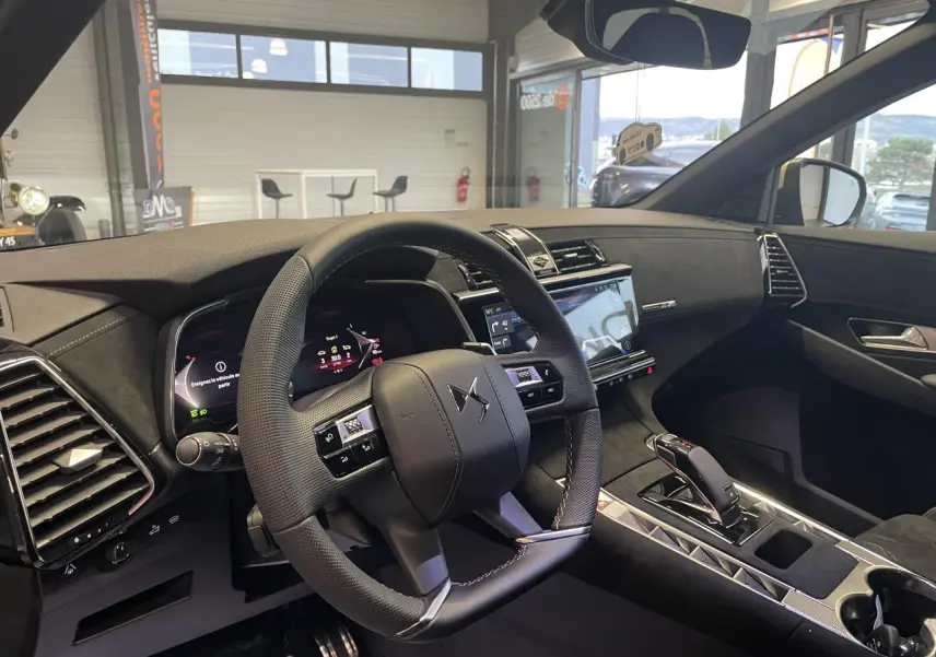 Vue intérieure côté conducteur du DS7 Crossback 2026 avec volant cuir perforé et tableau de bord Alcantara noir profond.