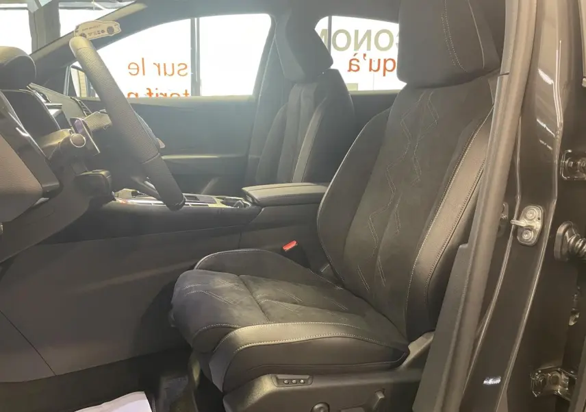 Vue intérieure côté conducteur du DS7 Crossback gris titanium, mettant en valeur les sièges en Alcantara noir profond avec surpiqûres.