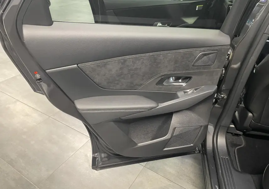 Porte arrière côté gauche ouverte d’un DS7 Crossback gris titanium, montrant le panneau intérieur en Alcantara noir et surpiqûres.