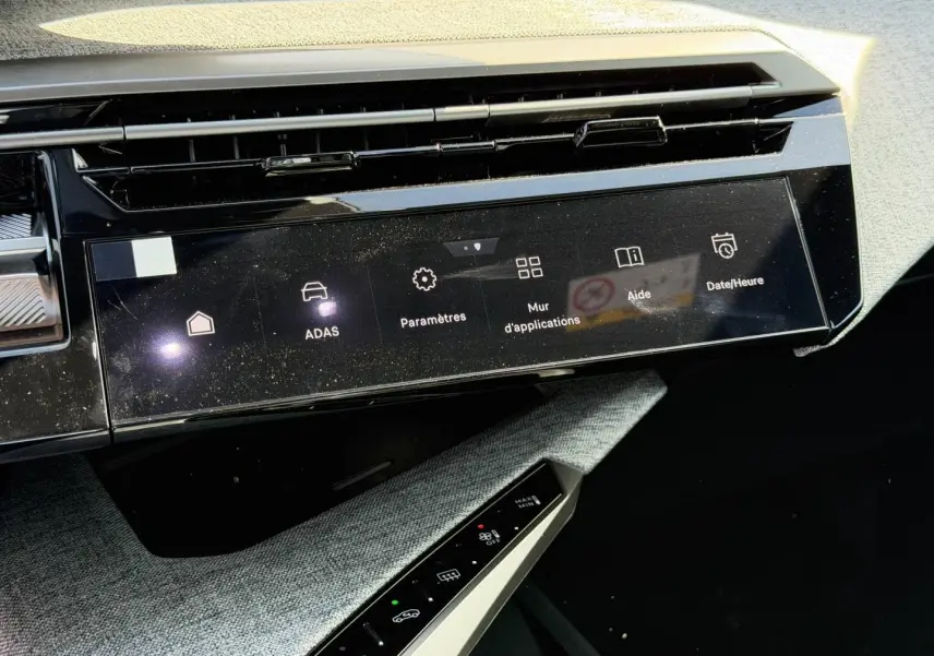 Vue rapprochée de la console centrale du Peugeot 3008 noir, écran tactile et commandes climatisation visibles.
