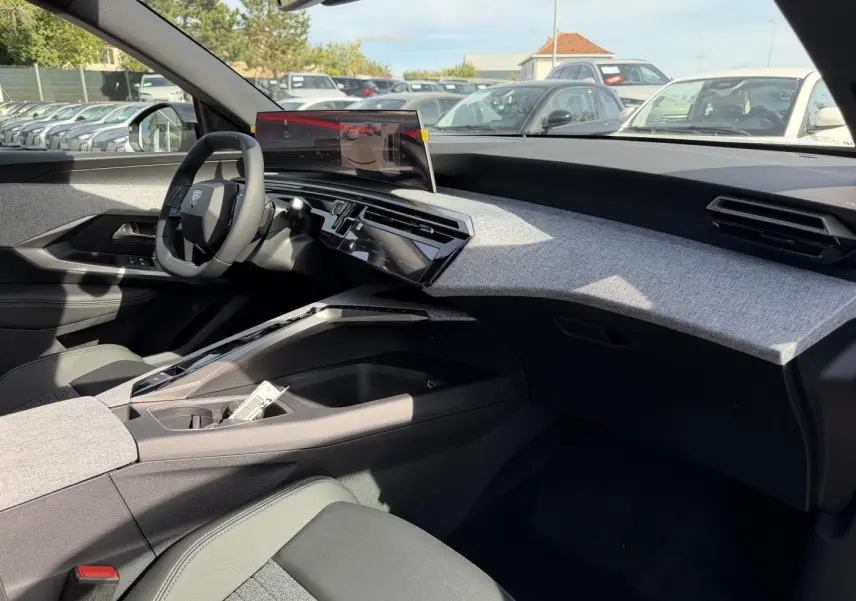 Vue intérieure côté passager du Peugeot 3008 2026, tableau de bord gris clair avec écran tactile flottant.