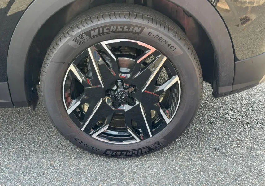 Gros plan sur la roue avant droite du Peugeot 3008 noir Perla Nera avec jante alliage noire et détails argentés.