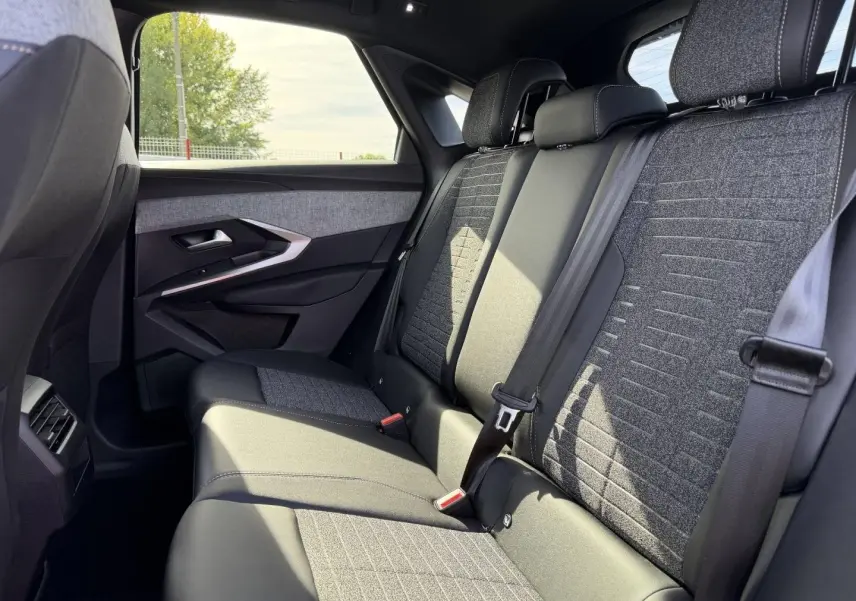 Vue latérale droite de la banquette arrière gris foncé et tissu CRISPY du Peugeot 3008 2026, avec ceintures de sécurité visibles.
