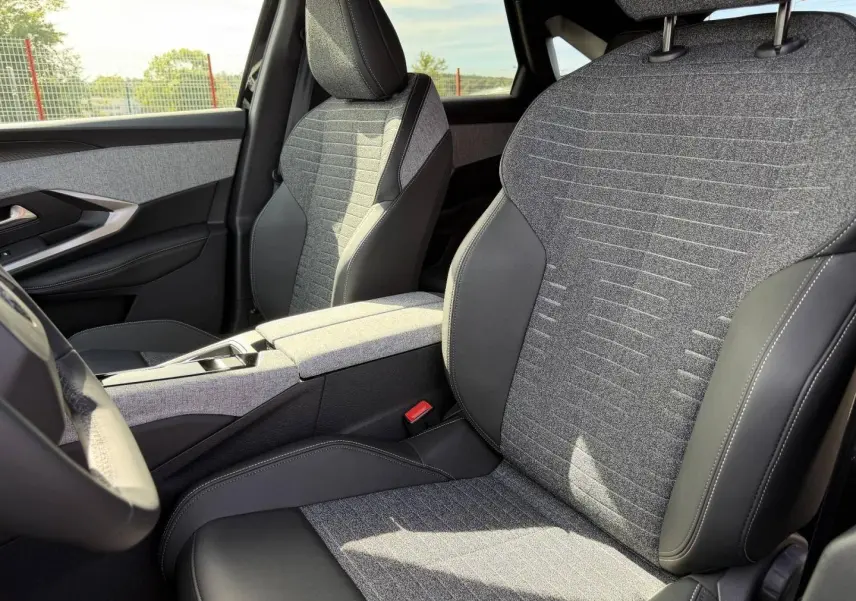 Vue intérieure rapprochée des sièges avant gris tissu et cuir du Peugeot 3008 Hybrid noir Perla Nera 2026.