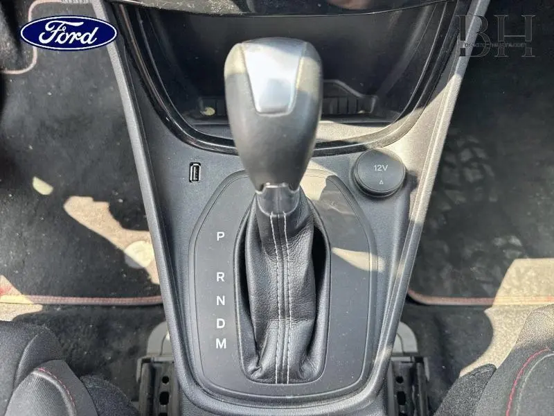 Le levier de vitesses automatique de la Ford Puma 1.0 EcoBoost rouge, vu de dessus avec coutures blanches visibles.