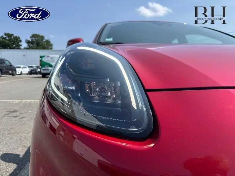 Gros plan sur le phare avant gauche du Ford Puma 2022 rouge métallisé, soulignant son design moderne et lumineux.