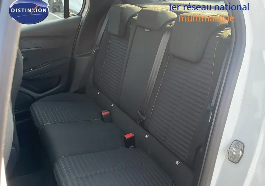 Vue intérieure côté arrière droit montrant les sièges arrière noirs sur Peugeot 208 blanc banquise 2024.