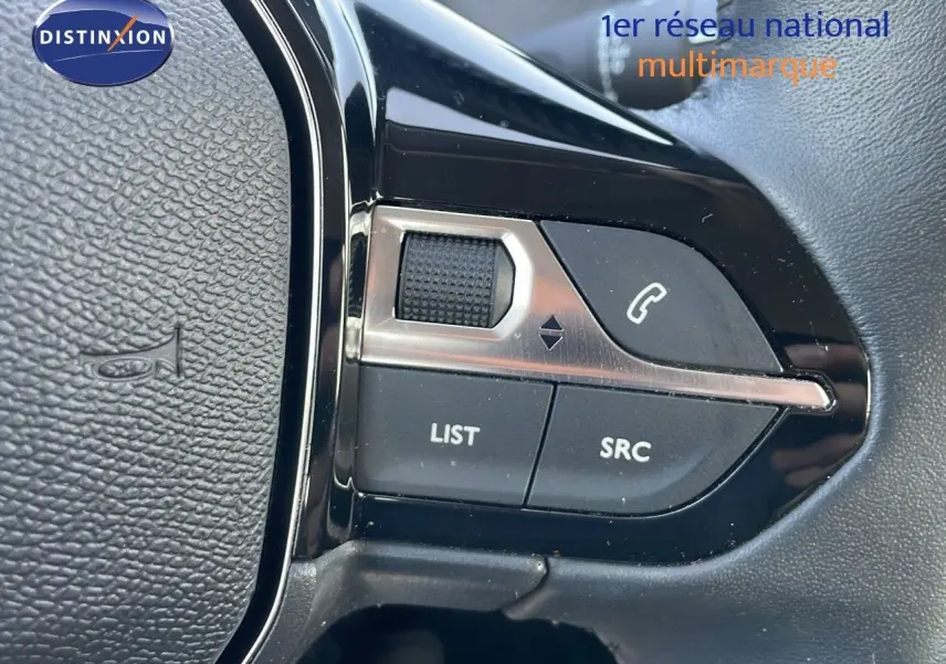 Gros plan sur les commandes au volant noir de la Peugeot 208 2024, avec boutons de gestion audio et appel.