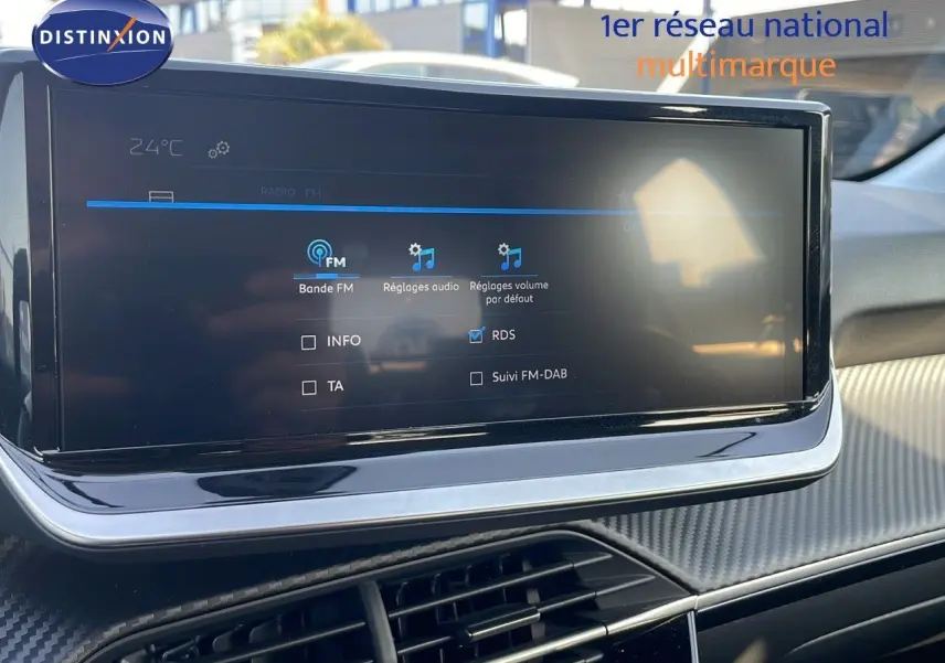 Écran tactile central affichant les réglages audio dans l’habitacle d’une Peugeot 208 blanc banquise 2024.