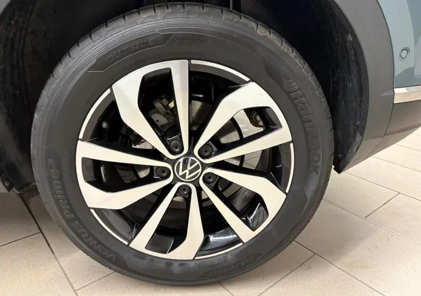 Gros plan sur la jante alliage bicolore du côté avant droit du Volkswagen T-Roc bleu pétrole 2025.