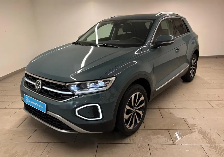 Volkswagen T-Roc bleu pétrole en 3/4 avant droit, avec signature lumineuse LED distinctive et jantes alliage.