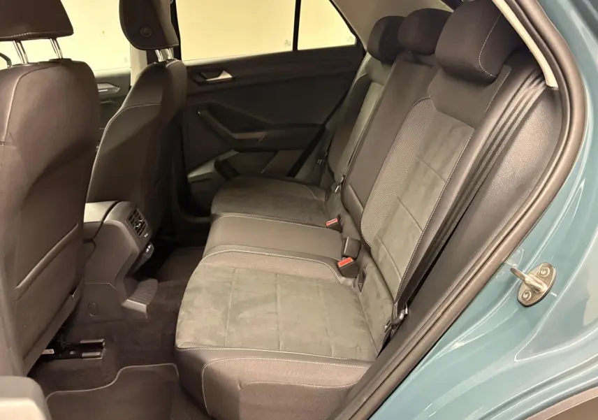 Vue intérieure arrière côté droit du Volkswagen T-Roc bleu pétrole, montrant les sièges arrière en tissu et alcantara.