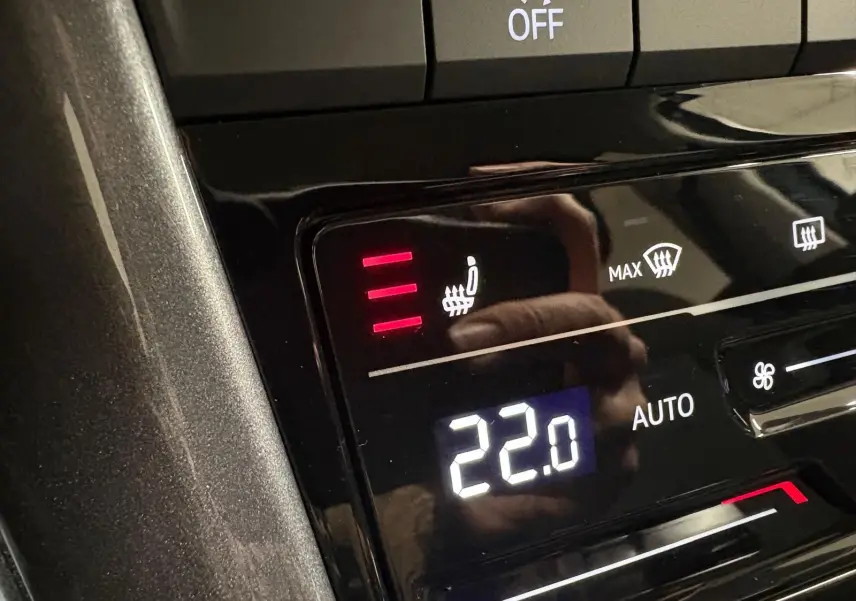 Gros plan sur la commande de chauffage des sièges avant allumé à trois niveaux dans un Volkswagen T-Roc 2025.
