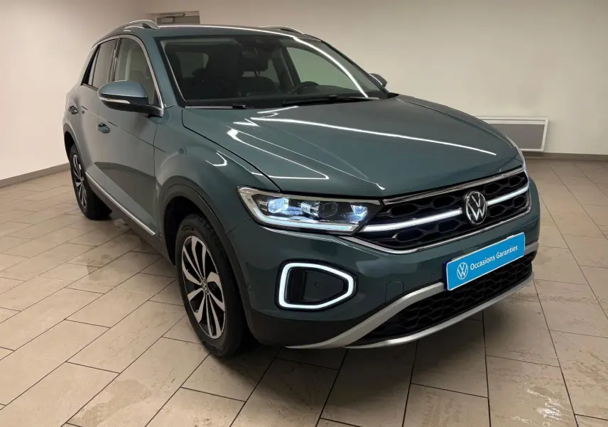 Volkswagen T-Roc 1.5 TSI bleu pétrole en 3/4 avant droit, avec feux LED et jantes alliage distinctives.