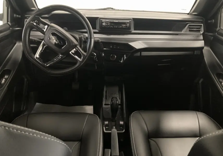 Vue intérieure frontale du tableau de bord noir de la Ligier JS50 0.5 REVO D+ avec volant et autoradio Pioneer intégré.