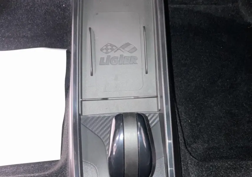 Vue plongeante sur la console centrale noire du Ligier JS50 2026 avec levier de boîte auto et logo Ligier visible.