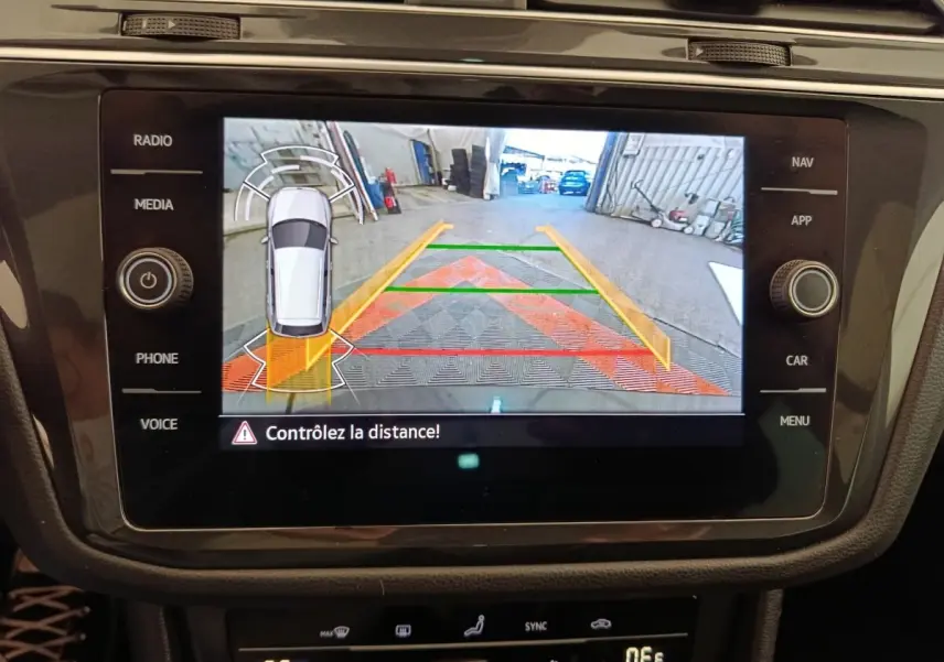 Vue rapprochée de l'écran tactile du tableau de bord affichant la caméra de recul avec guidage couleur du Volkswagen Tiguan noir.