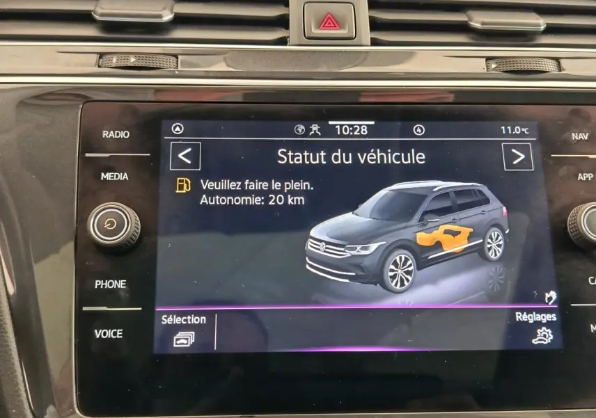 Écran tactile du tableau de bord affichant le statut du Volkswagen Tiguan noir avec autonomie et alerte carburant.