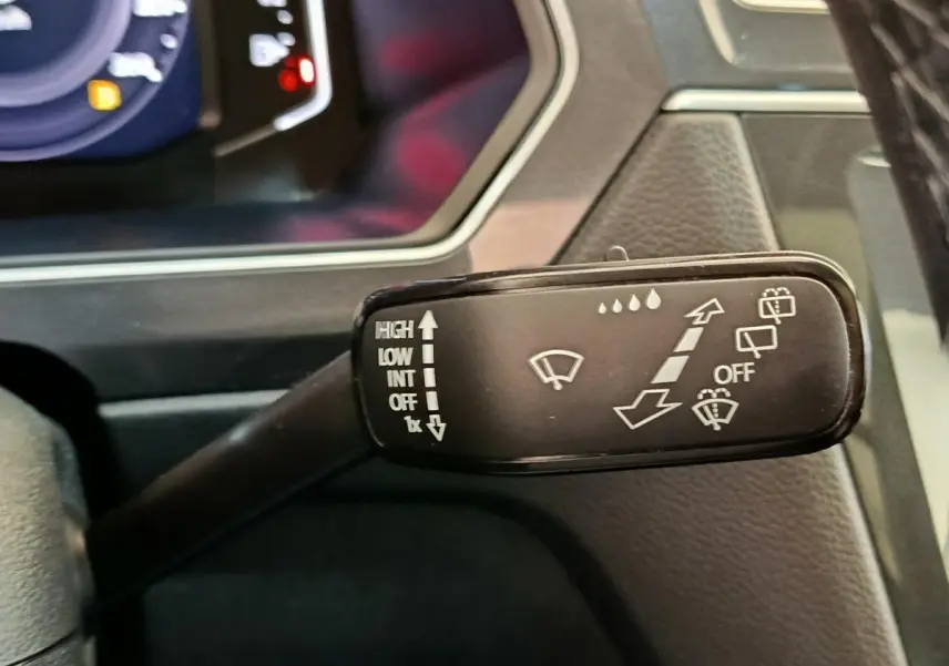 Gros plan sur la commande d’essuie-glace du Volkswagen Tiguan 2.0 TDI 150 DSG7 Elegance, intérieur noir.
