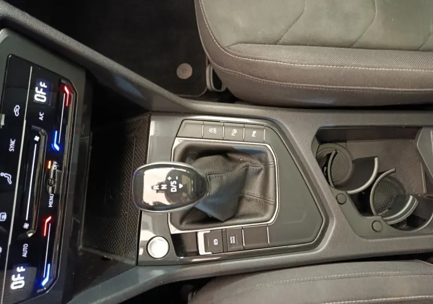 Vue plongeante sur la console centrale noire du Volkswagen Tiguan 2.0 TDI 150 DSG7 avec levier de vitesse et commandes tactiles.