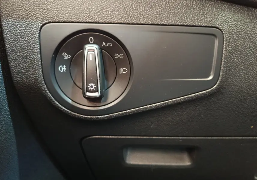 Gros plan sur le bouton de commande des phares dans l’habitacle du Volkswagen Tiguan noir, version 2022.