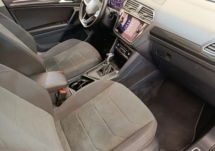 Vue intérieure côté conducteur du Volkswagen Tiguan 2.0 TDI 150 DSG7 Elegance avec sièges gris et tableau de bord numérique.